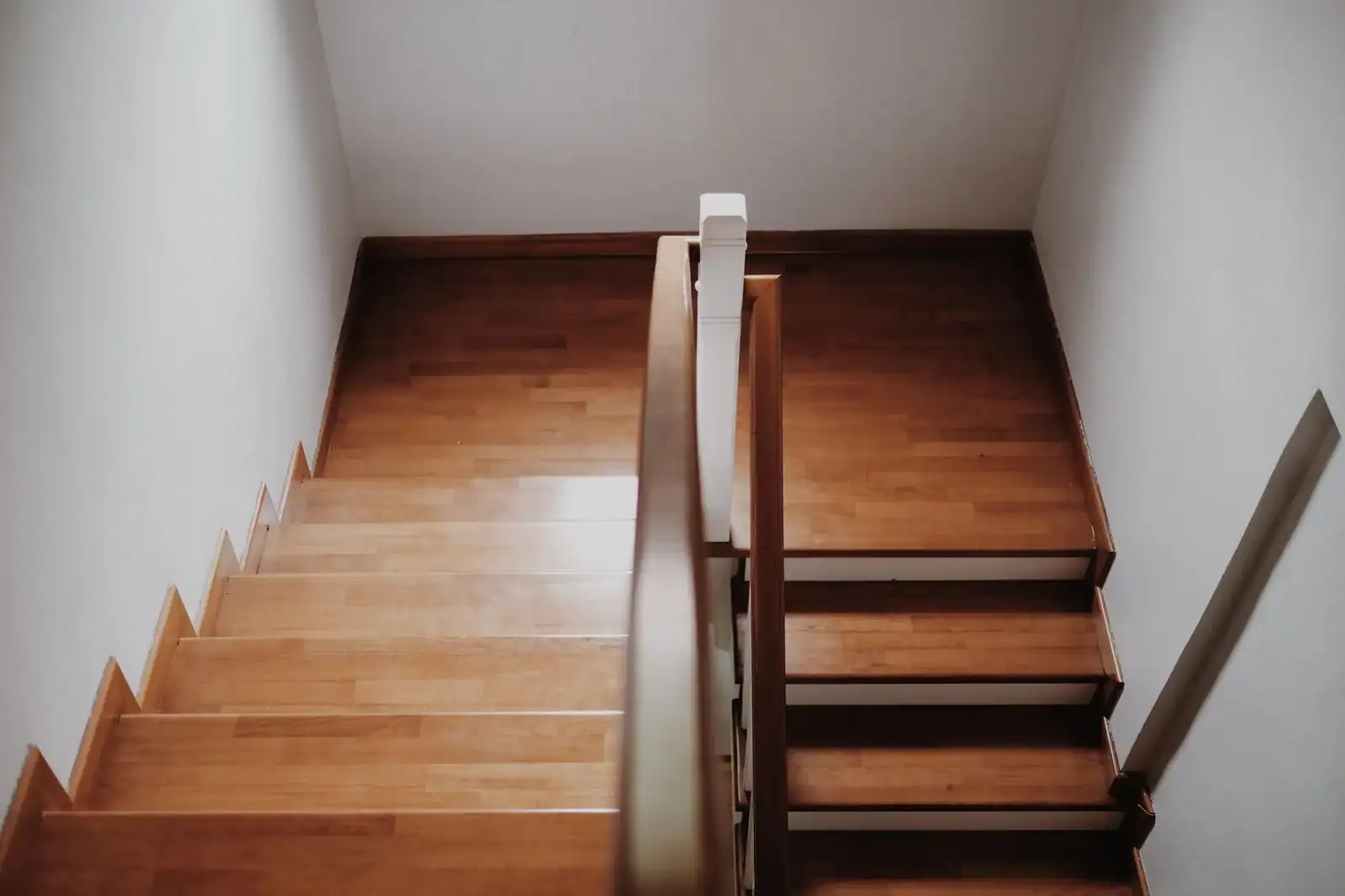 Top view of a wooden staircase in a minimalist interior, showcasing clean lines and elegant design.