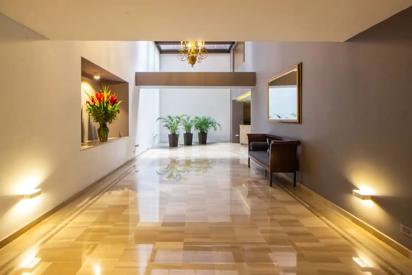 Luxurious hallway featuring marble flooring, decorative plants, and modern interior design.