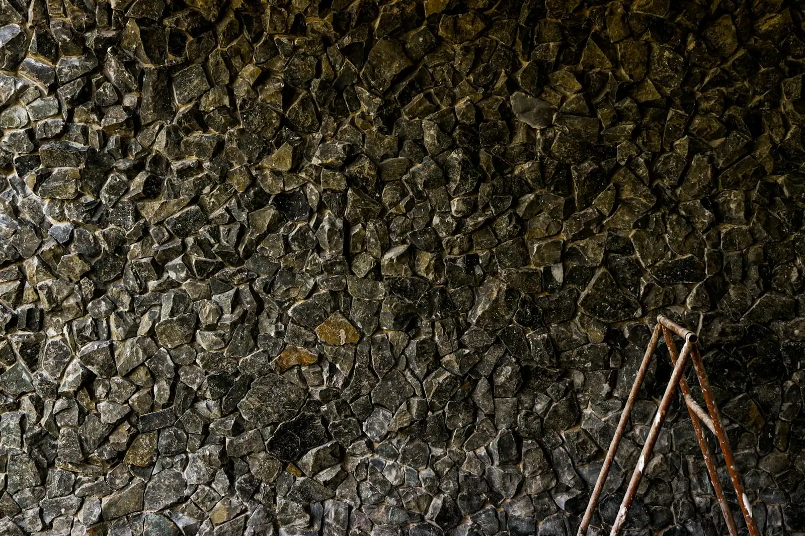 Textured stone wall with rustic ladder in São José do Rio Preto, Brazil.