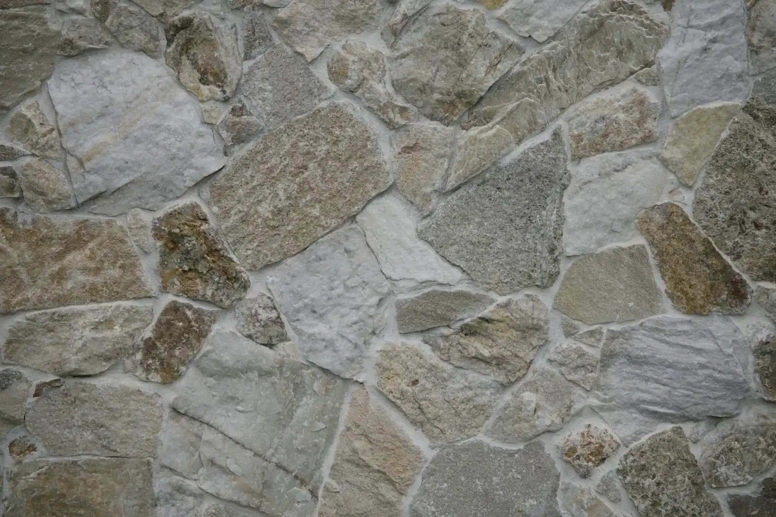 Close-up of a textured stone wall, featuring natural patterns and varied shades.