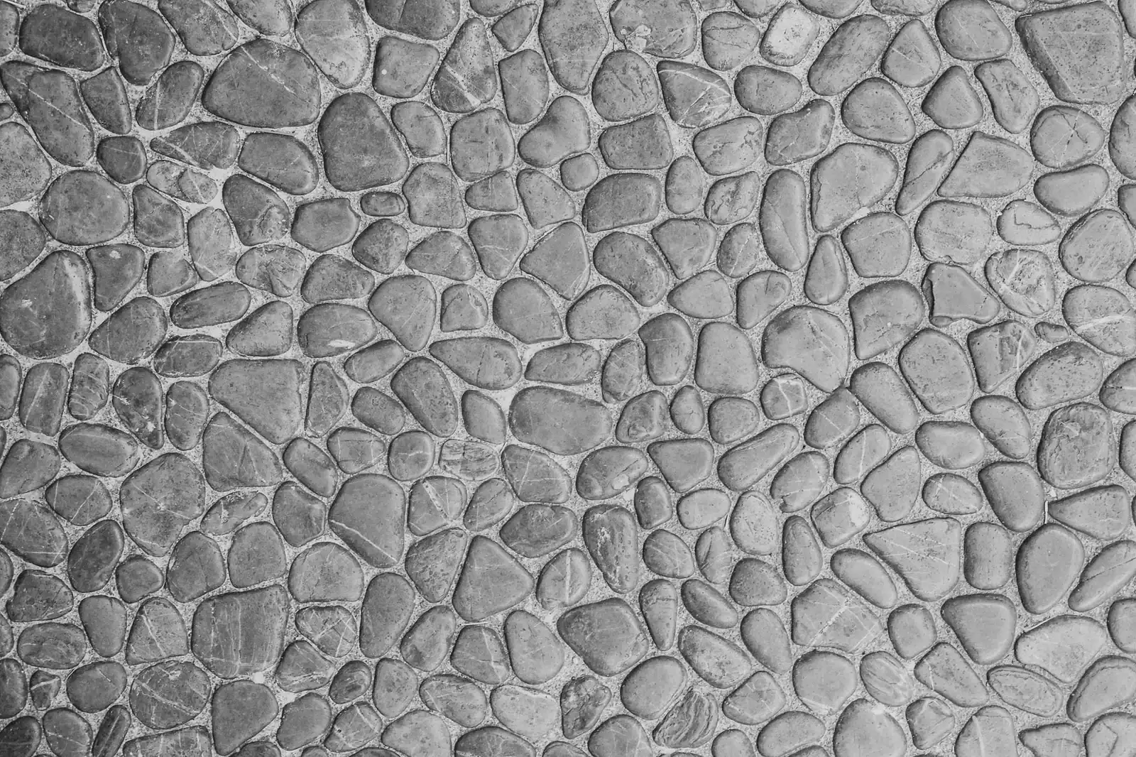 Detailed close-up of gray stone wall with a cobblestone pattern, perfect for architectural design.