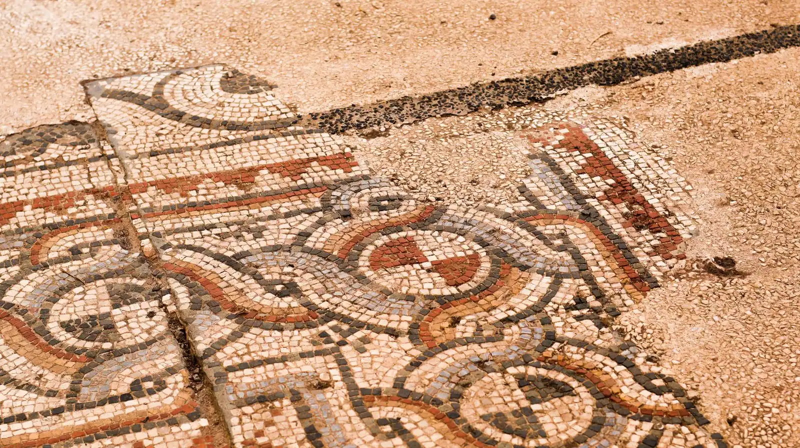Intricate ancient Roman mosaic displaying geometric patterns with earthy hues.