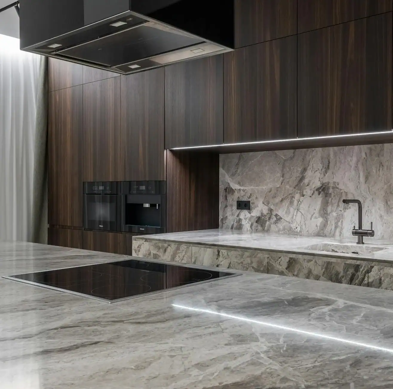Interior design of spacious stylish modern kitchen with induction stove and air extraction system with wooden cupboards